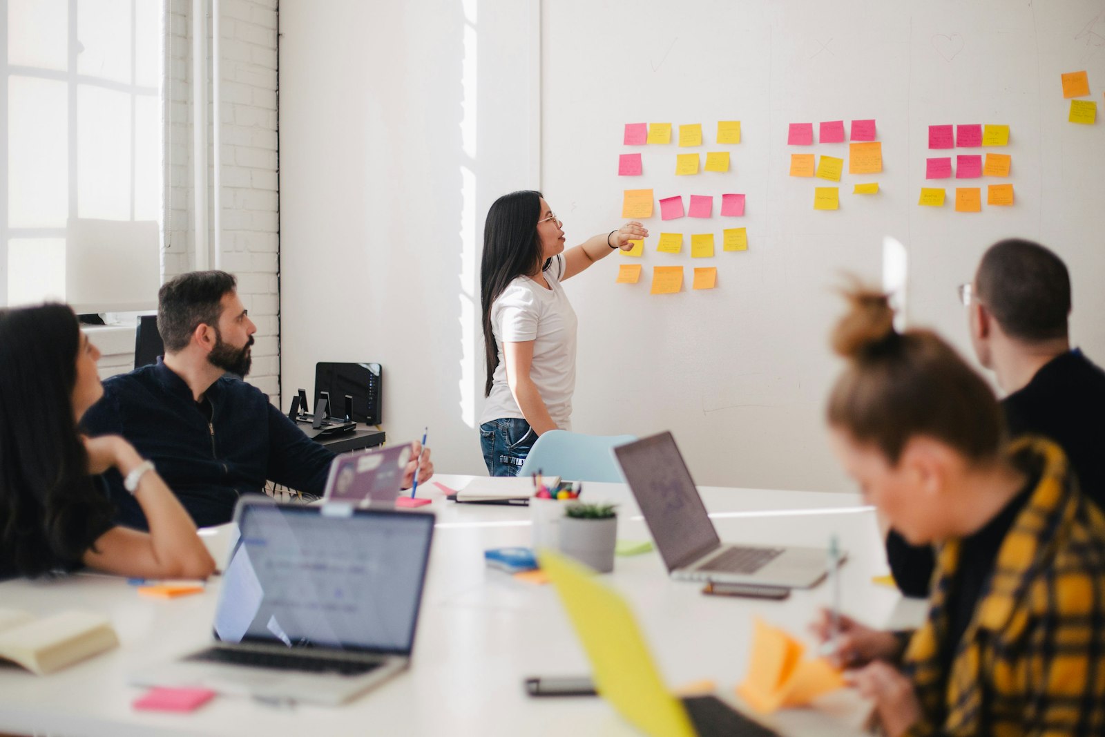 Team brainstorming with sticky notes on a glass wall